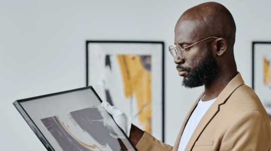 man-holding-framed-art